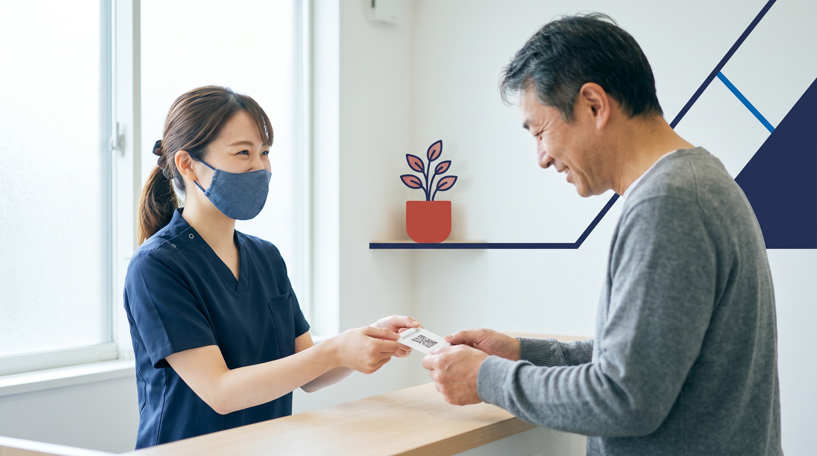 クリニックのスタッフが患者にQRカードでGoogle口コミをお願いする様子